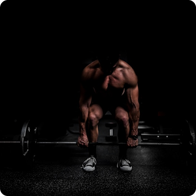 Athlete deadlifting in dark gym